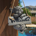 Dragon-shaped welcome sign hanging on a wooden post with a pool and house in the background.