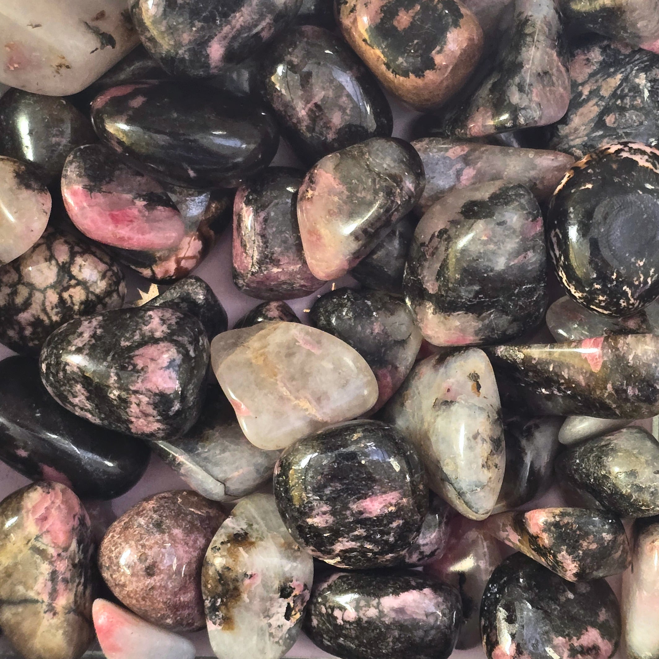 A pile of tumbled Rhodonite crystals