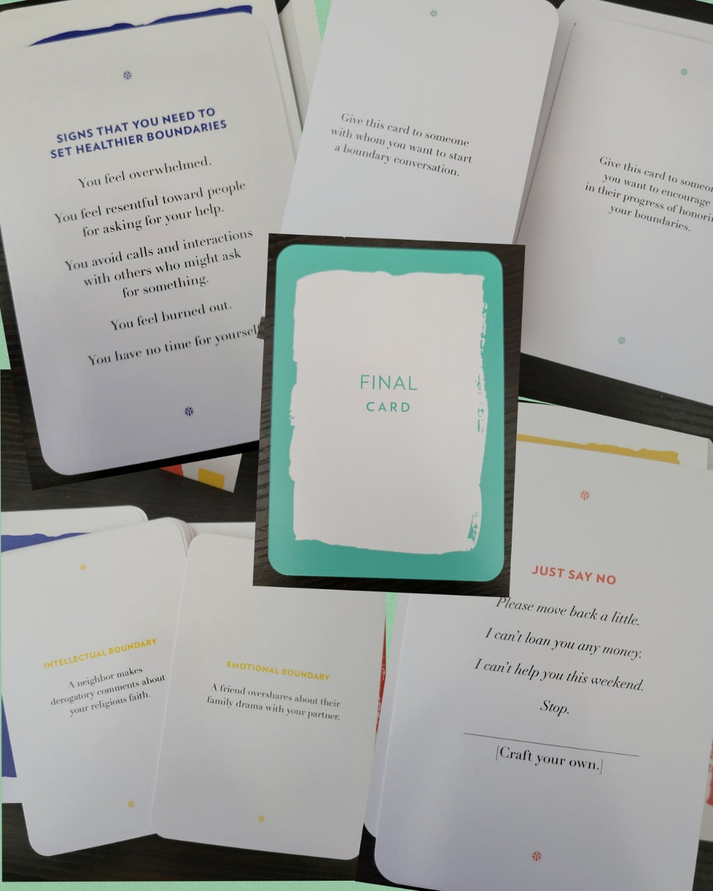 A set of printed cards laid out on a dark surface, including a central card labeled 'FINAL CARD' with a mint green border, surrounded by other white cards with text prompts and small colored dots.