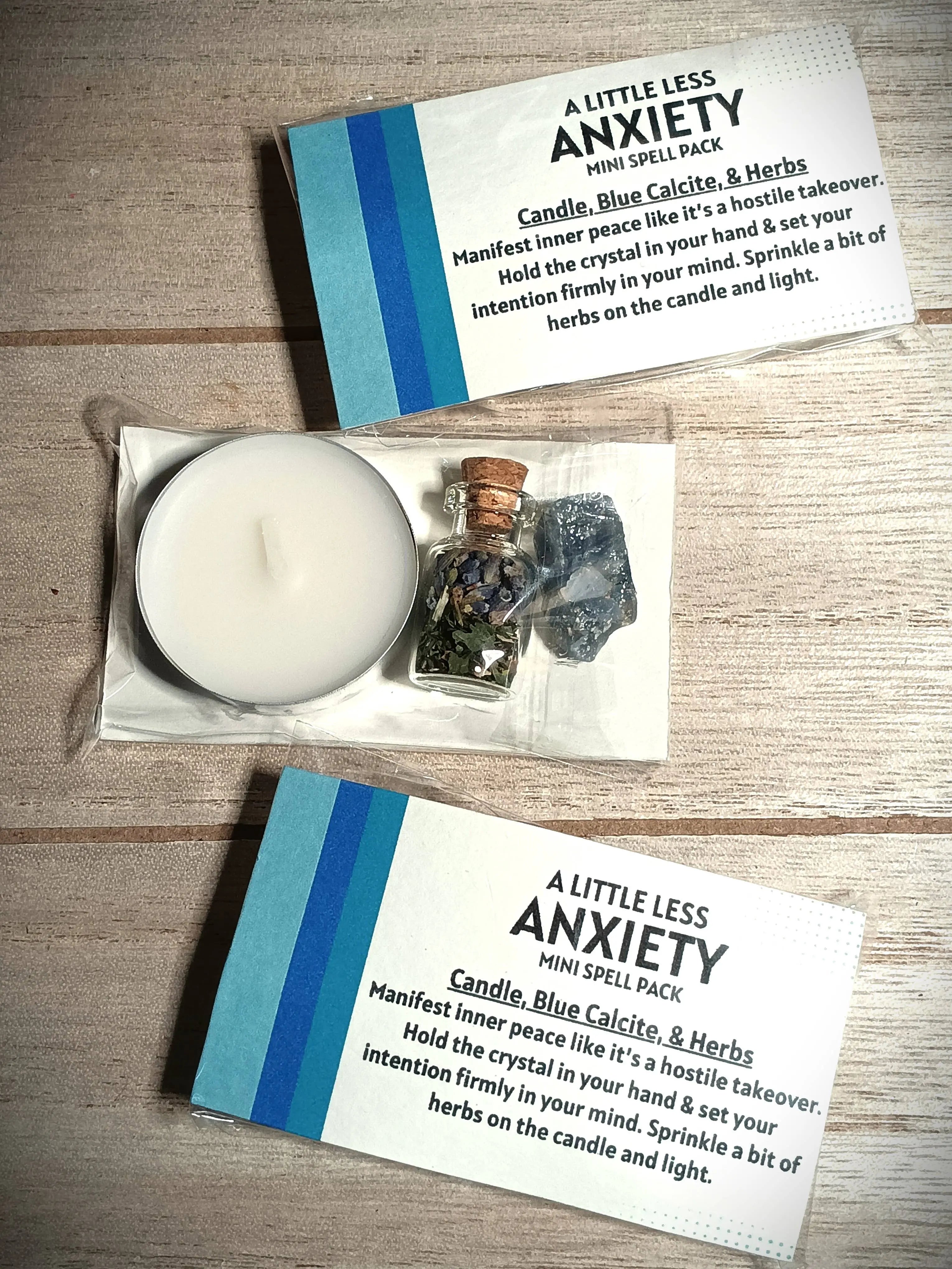 Mini spell pack for anxiety with candle, blue calcite, and herbs on a wooden surface