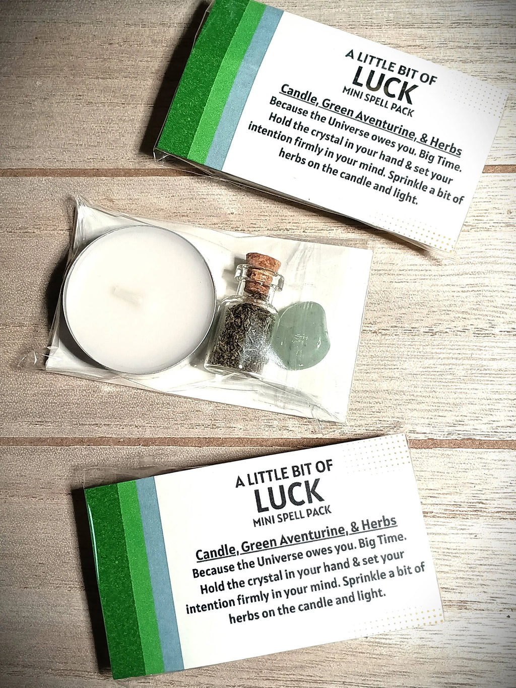 Mini spell pack with candle, green aventurine, and herbs on a wooden surface
