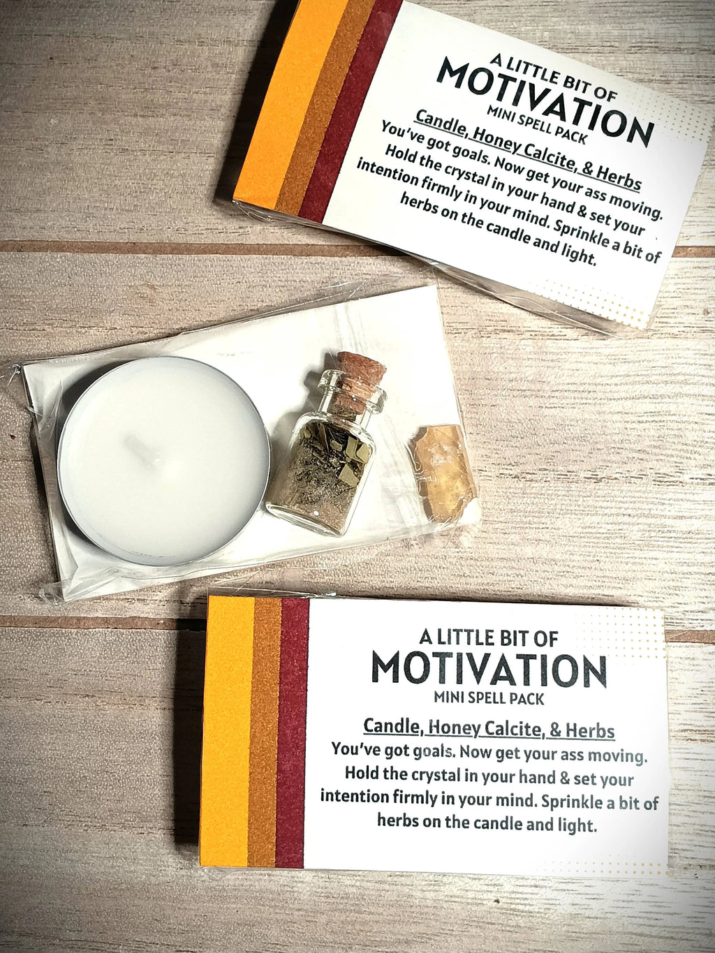 Mini spell pack with candle, bottle, and herbs on a wooden surface