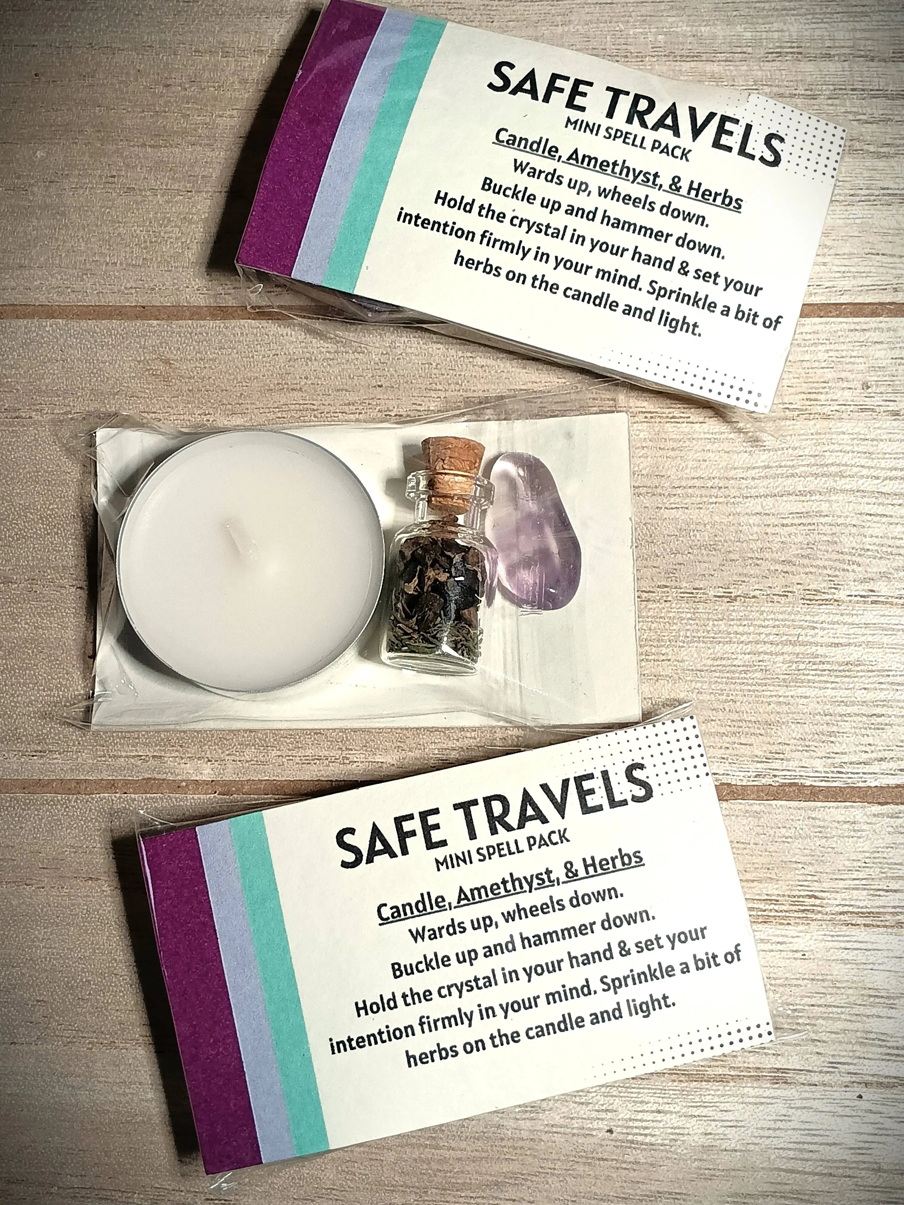 Safe Travels mini spell pack with candle, amethyst crystal, and herbs on a wooden surface.