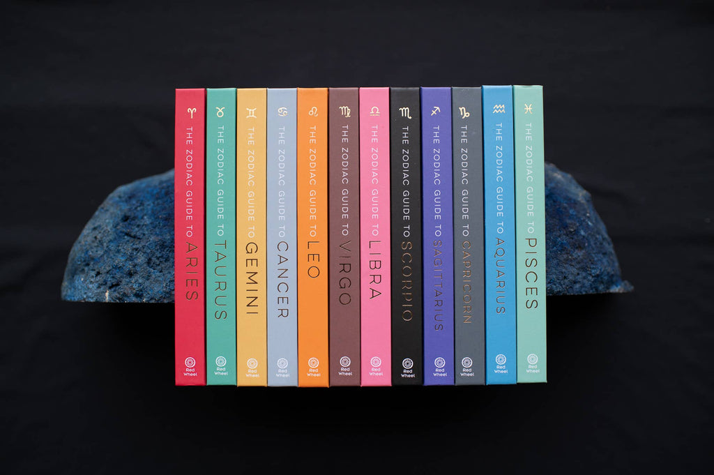 Set of books titled 'The Zodiac Guide to Astrology' by Zadie Smith on a dark background.