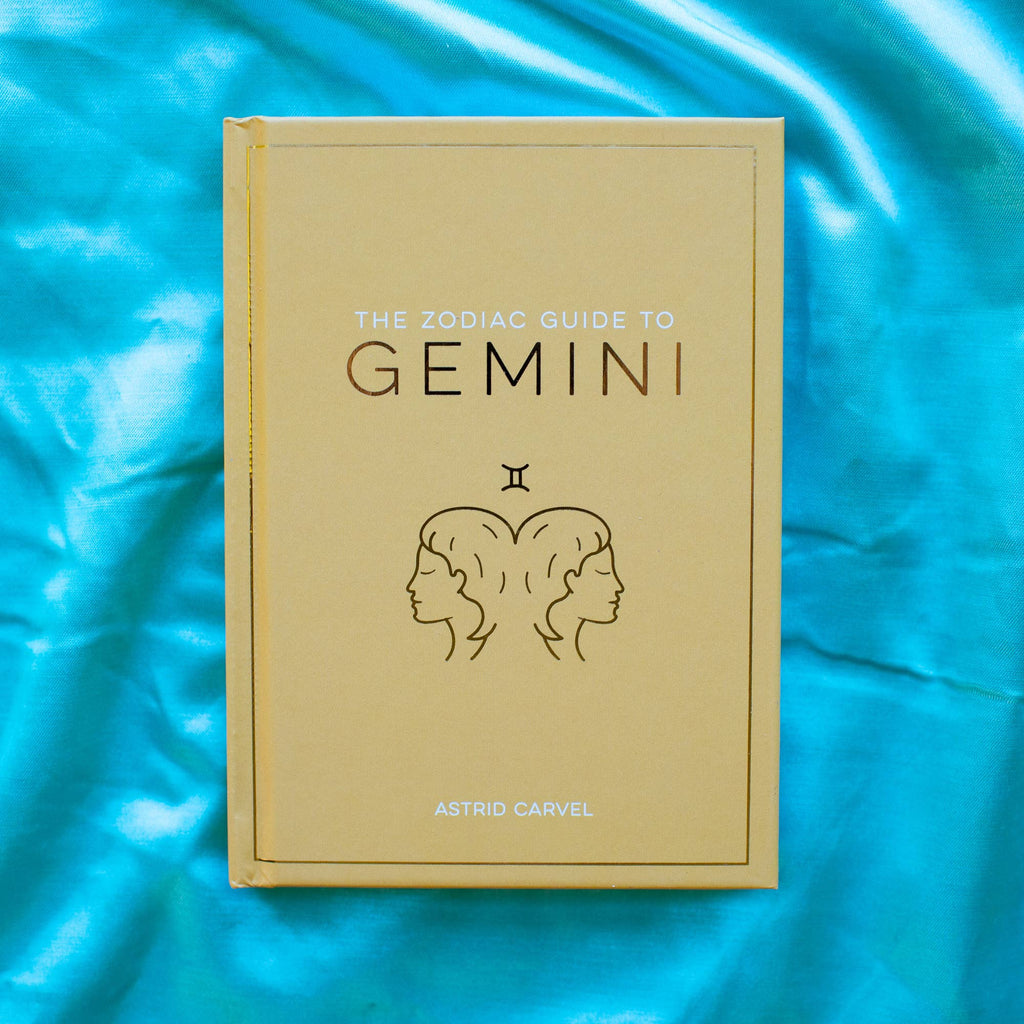Book titled 'The Zodiac Guide to Gemini' on a blue fabric background