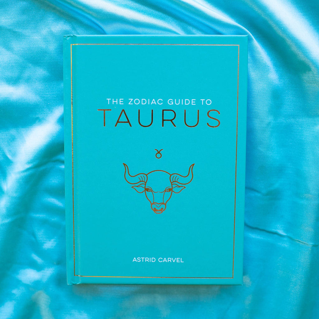 Book titled 'The Zodiac Guide to Taurus' on a blue textured background