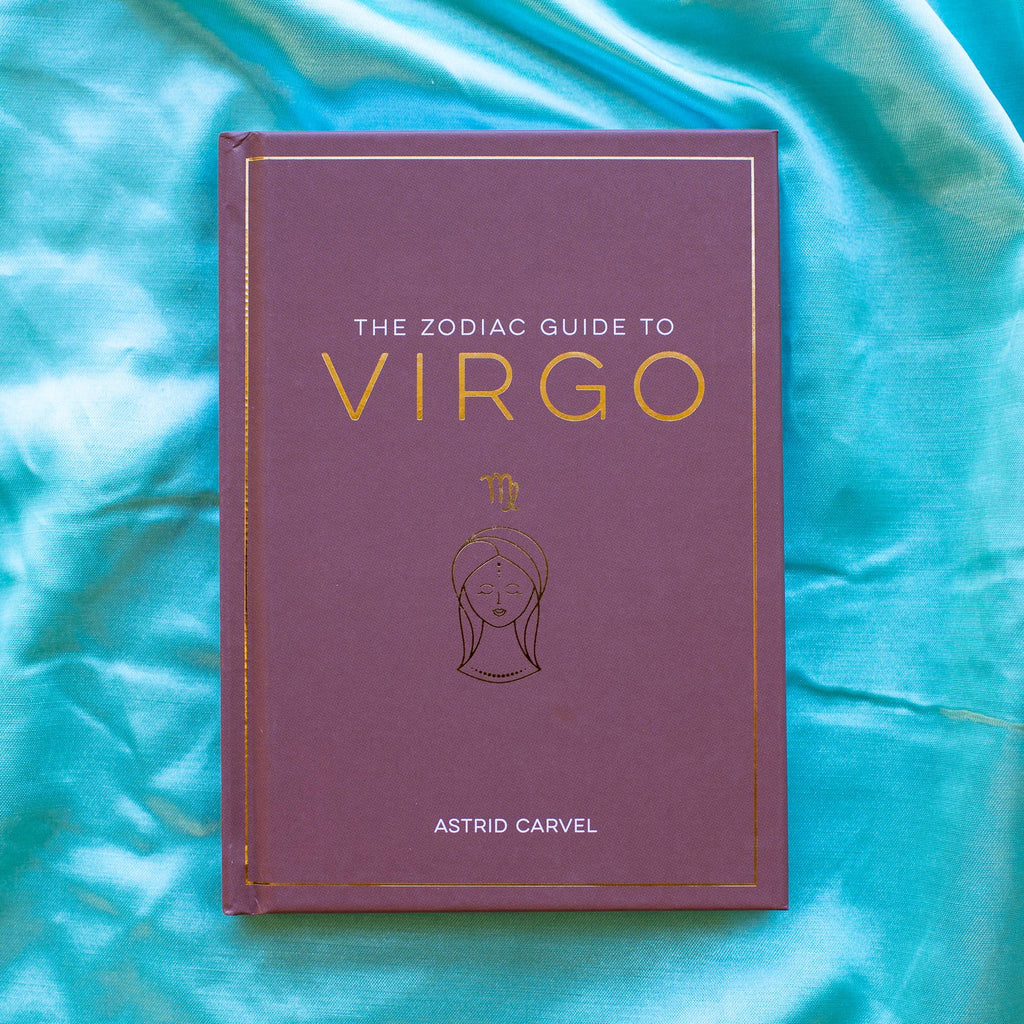 Book titled 'The Zodiac Guide to Virgo' by Astrid Carvel on a turquoise fabric background