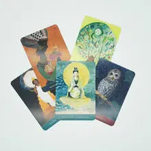 Five illustrated tarot or oracle cards fanned out on a light gray background, each showing a different fantasy-style artwork including a tree, moon, owl, and celestial figures.