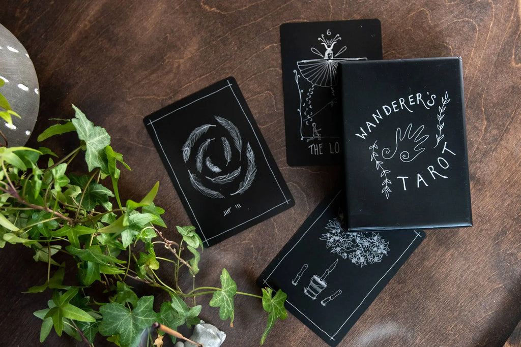 Wanderer's Tarot cards on a wooden surface with plants.