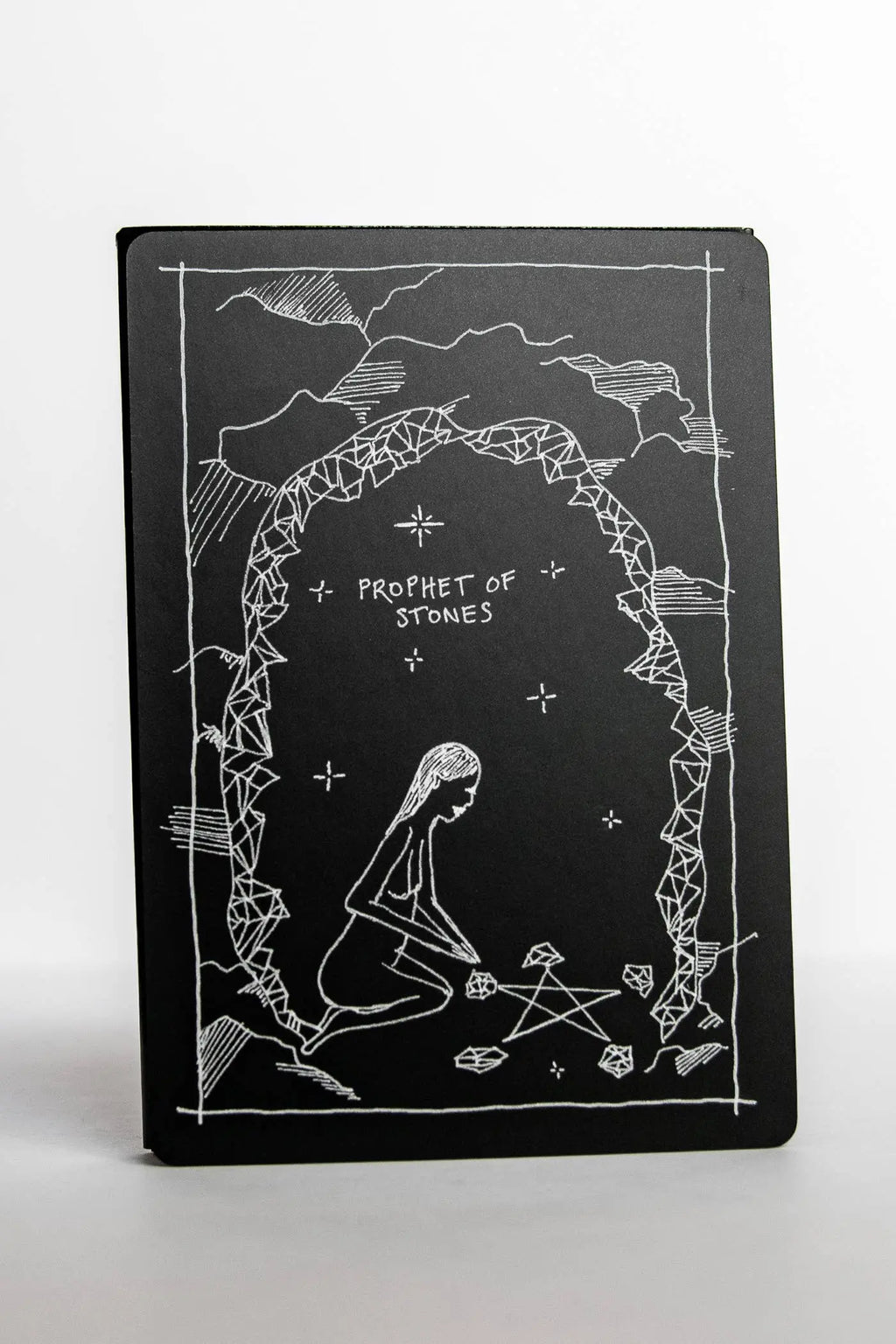 Black notebook with white illustrations and text on a white background