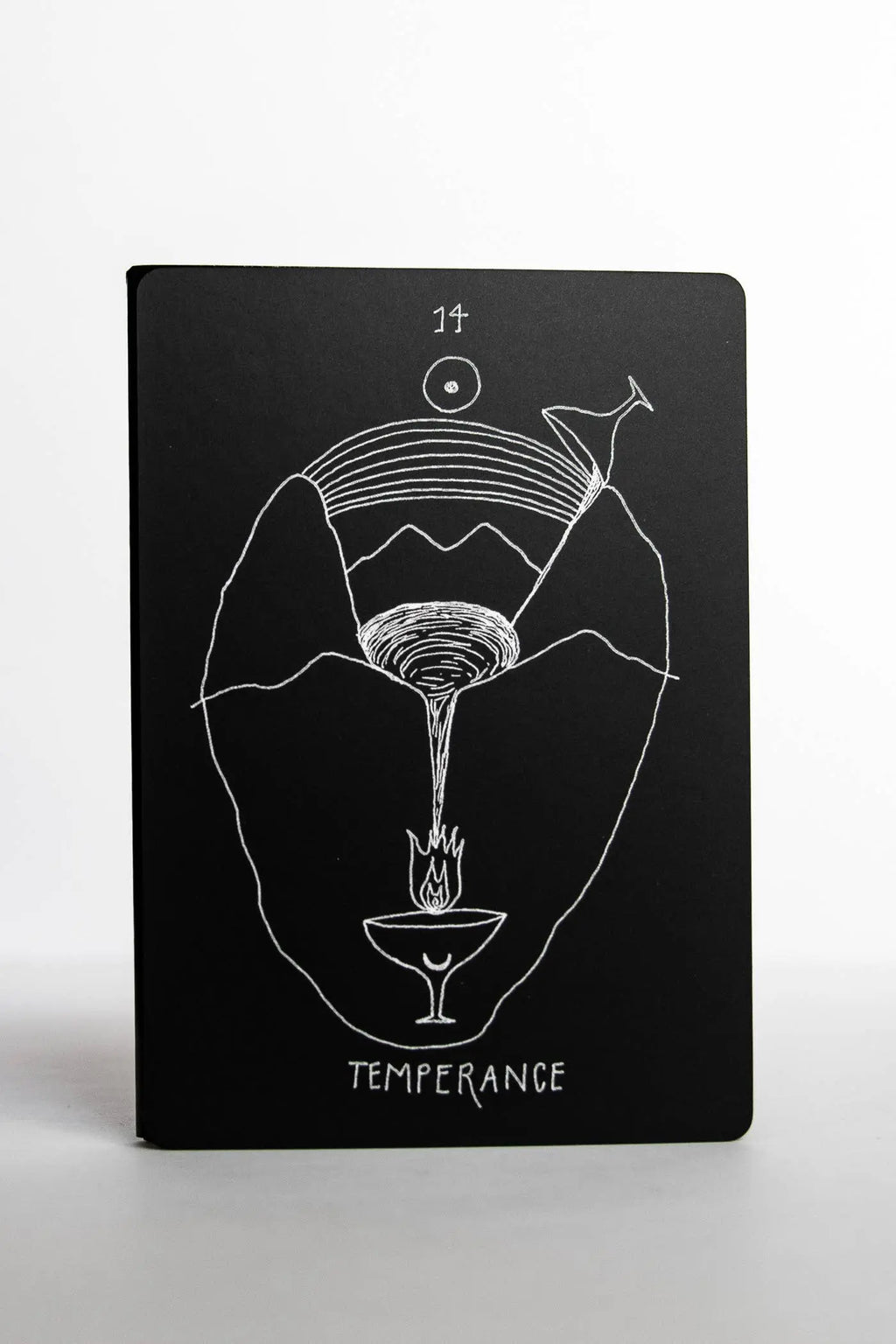 Black notebook with white line art design and 'Temperance' text on a white background