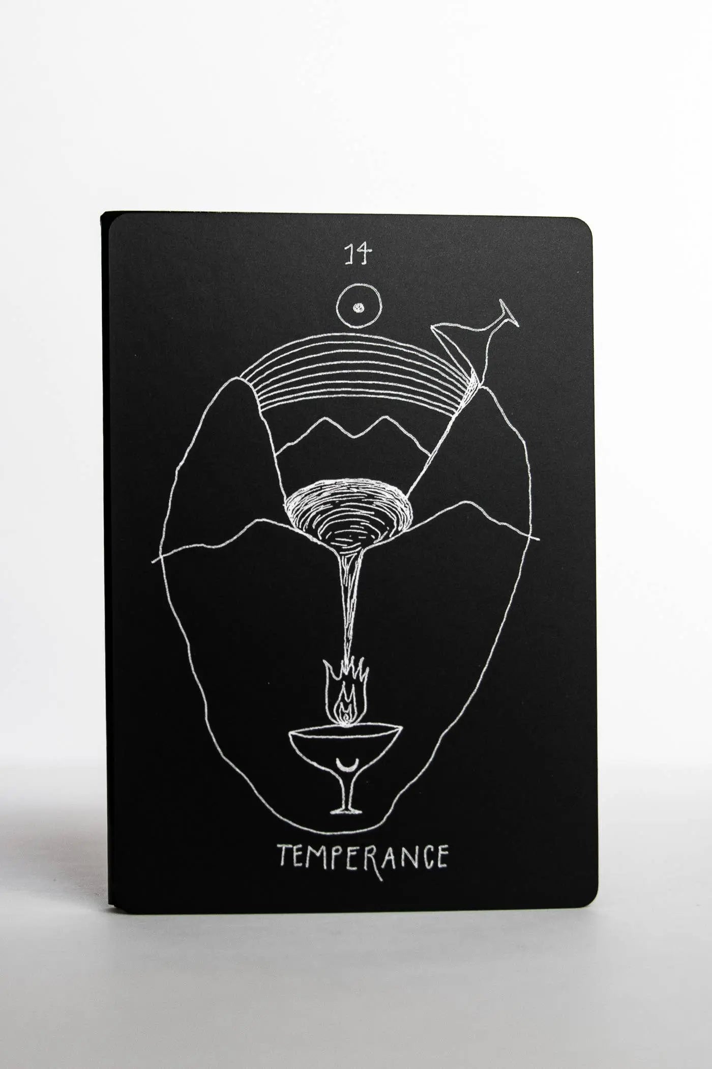 Black notebook with white line art design and 'Temperance' text on a white background