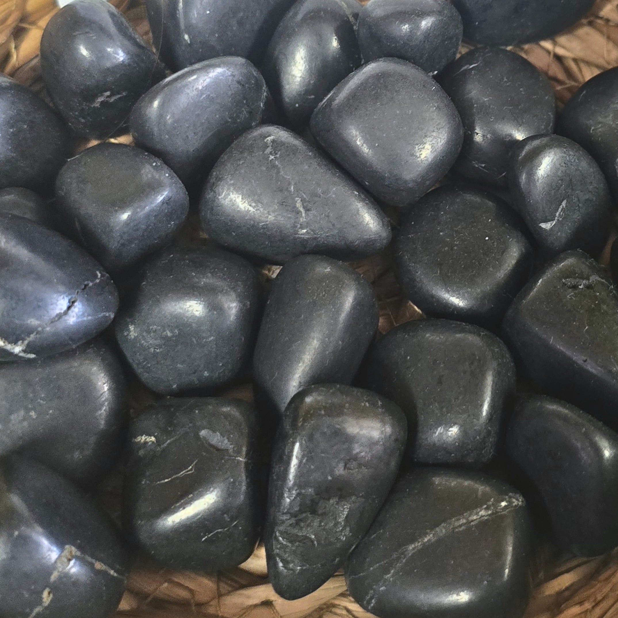 A pile of tumbled shungite crystal